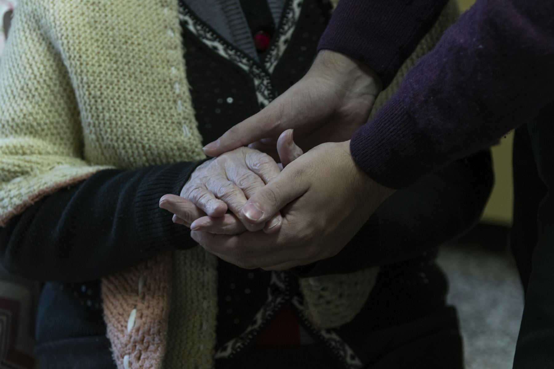 Cura domiciliària: mans d'una persona gran amb una cuidadora.